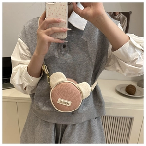 Dettaglio mini borsa a forma di orso rosa e beige con fibbia in metallo dorato
