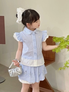 Détail d'une tenue d'été rayée pour enfants avec broderie étoile de mer et col en dentelle