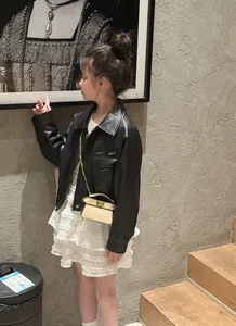 Detail of children's faux leather biker jacket with zippers and chic chain strap bag