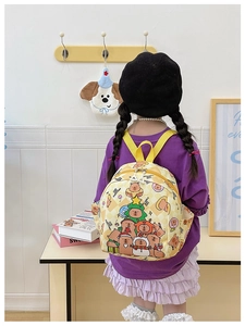Kids backpack with yellow checkerboard pattern and cartoon bear print shown on a model