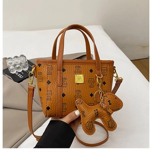 Detail der Bucket Bag mit Katzenmuster, Bärenanhänger und goldener Hardware