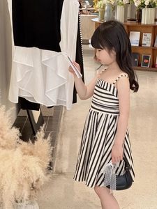 Détail d'une robe chic à rayures noires et blanches pour fille avec sac en dentelle