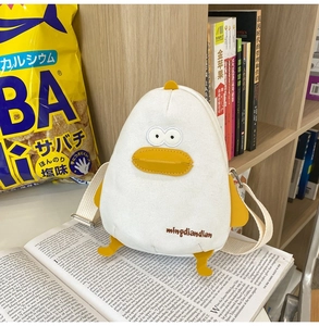 Detail of cute duck canvas crossbody bag with 3D beak on an open magazine