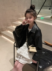 Mini beige chain bag with silk scarf and metal lock paired with black leather jacket