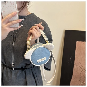 Dettaglio mini borsa rotonda a tracolla con orecchie graziose e logo LKXIONG dorato