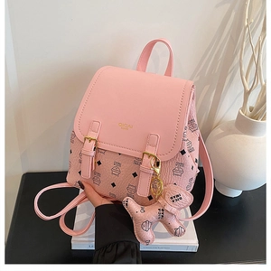 Pink QICAI MAO backpack detail showing cat print, leather buckle, and dog charm