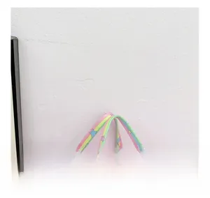 Detail of pink sequin backpack with rainbow webbing handles and colorful star patterns