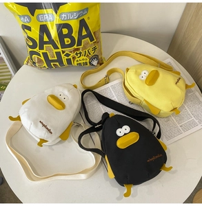 Flat lay of cartoon duck canvas bags in yellow black and white with adjustable straps