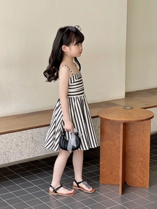 Détail d'une robe d'été pour enfants à rayures noires et blanches avec une coupe trapèze