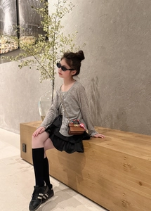 Girl's mini brown leather handbag with a silk scarf handle shown in an outdoor outfit