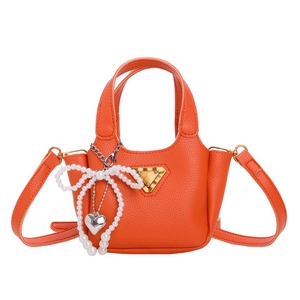Mini borsa arancione per bambini con fiocco di perle e trama litchi su sfondo bianco