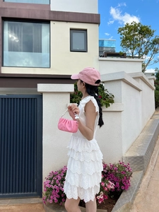 Détail du sac à main plissé rose avec bandoulière perle et robe en dentelle pour fille