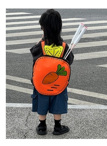 Detail of cartoon carrot backpack showing dual shoulder straps and badminton racket storage