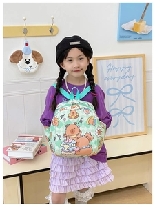 Girl wearing a mint green checkerboard backpack with cartoon bear and strawberry prints