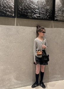 Mini brown leather crossbody bag with metal clasp styled for artistic kids fashion