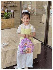 Detail view of a lavender plaid toddler backpack featuring a cute cartoon bear print