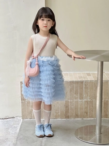 Détail d'une tenue d'été pour fille avec haut beige et jupe en tulle bleu