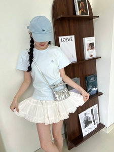 Chic silver pleated crossbody bag styled with a blue tee and white lace mini skirt