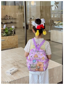 Close-up of a purple cartoon bear backpack with rhombus pattern and double zippers