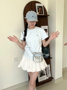 Silver mini crossbody bag with a bow detail styled with a white summer outfit