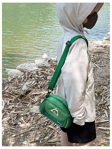 Detail of green outdoor crossbody bag with side mesh pocket and adjustable strap