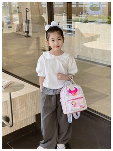 Detailed view of kids sequin unicorn backpack with rainbow straps worn by a little girl