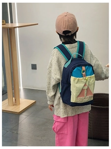 Detail of multi-color block children backpack with TOCHASO logo and durable nylon texture