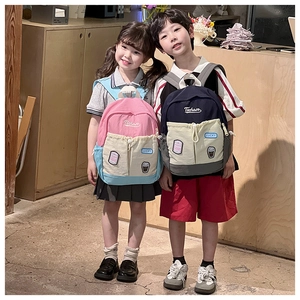 Detail view of stylish color-block kids backpack with drawstrings and embroidery