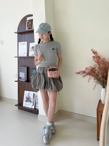 Close-up of pink pleated cloud bag with cute bow detail on a stylish girl outfit