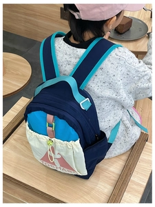 Detail of color-block kids backpack with durable nylon fabric and drawstring front pocket