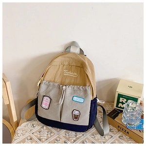 Detail of color-block kids backpack with Tochaso embroidery and decorative patches