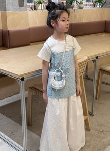 Fille portant un sac croissant argenté avec nœud en dentelle et tenue à pois
