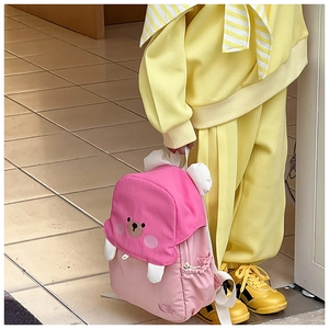 Detail of pink cartoon bear backpack showing rose red lid and cute 3D ears for children