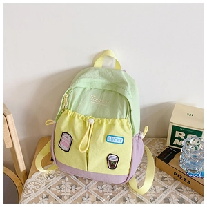 Detail of color-block backpack with embroidered patches and pockets on lace tablecloth