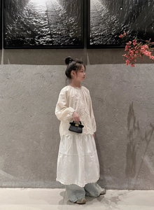 Detail of a mini black chain handbag styled with a minimalist girl's floral lace outfit