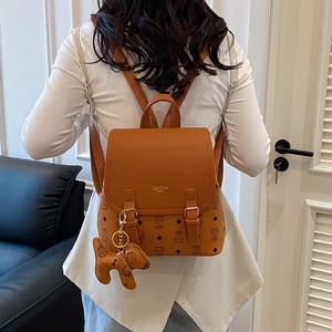Brown patchwork casual backpack with cat pattern and gold clasp shown on a model