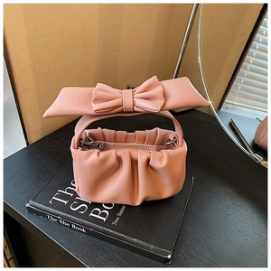 Detailed view of pink pleated girl's cloud bag with large bow and silver metal zipper