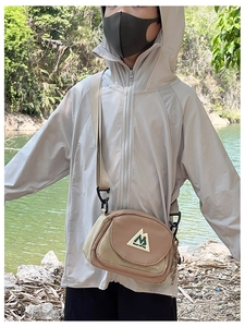Close-up of children's khaki outdoor crossbody bag featuring mountain embroidery detail