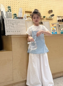 Détail d'un top bleu à pois avec t-shirt blanc et pantalon large pour enfants