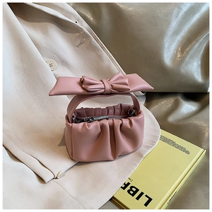 Detail of dusty rose cloud bag featuring soft pleated texture and large decorative bow