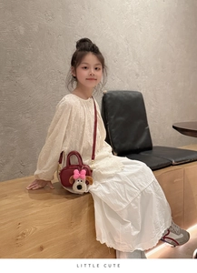 Dettaglio borsa per bambini in pelle bordeaux con ciondolo a forma di cucciolo di peluche