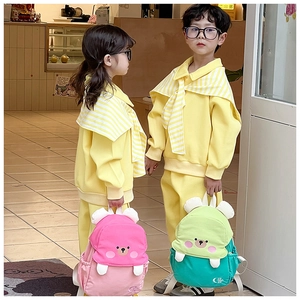 Detailed view of pink and teal cartoon bear backpacks with stylish kids hoodies