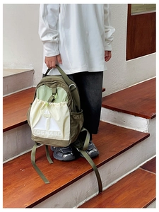Detail of child's olive and cream backpack with drawstring pocket and TOCHASO print