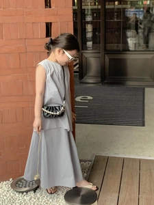 Détail du sac à main cœur perlé assorti à une tenue grise pour enfant chic