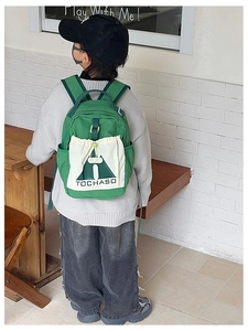 Rear view of a child wearing a stylish green backpack with white drawstring pocket detail