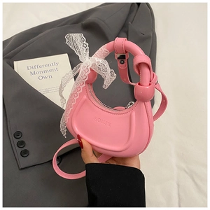 Détail du sac croissant en cuir mat rose avec poignée nouée et nœud en dentelle