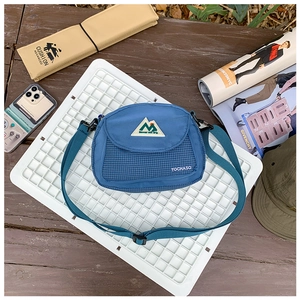 Detail view of a blue children's crossbody bag with mesh pocket and adjustable strap