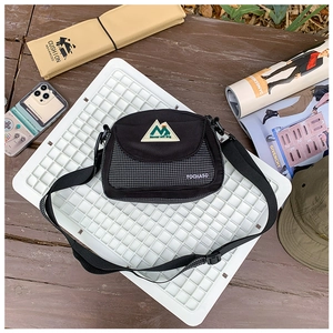 Detail view of the black nylon kids crossbody bag with plaid stitching and adjust strap