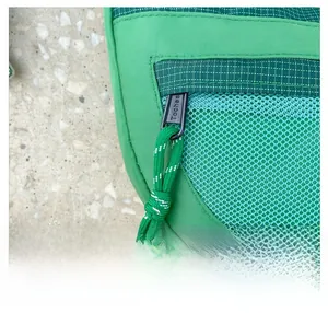 Détail du sac enfant en nylon vert avec fermeture éclair, cordon et poche filet