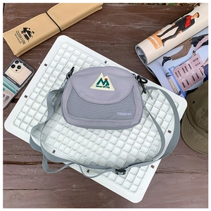 Detail of light gray nylon kids shoulder bag with front mesh pocket and mountain logo